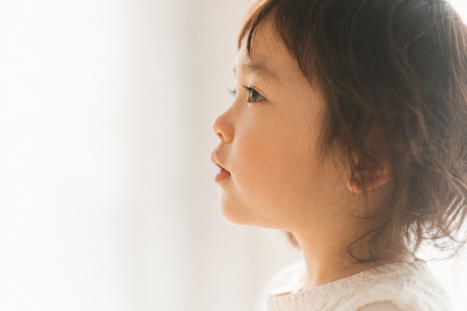 窓の外を見つめる子どもの横顔