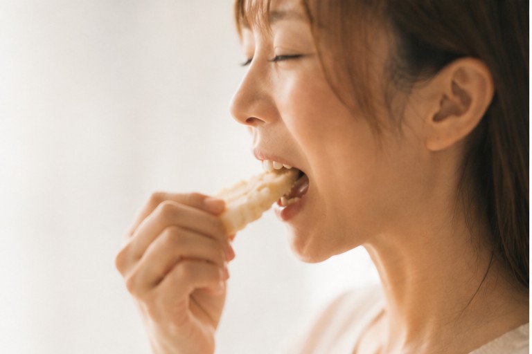 食べ物を口に運ぶ女性